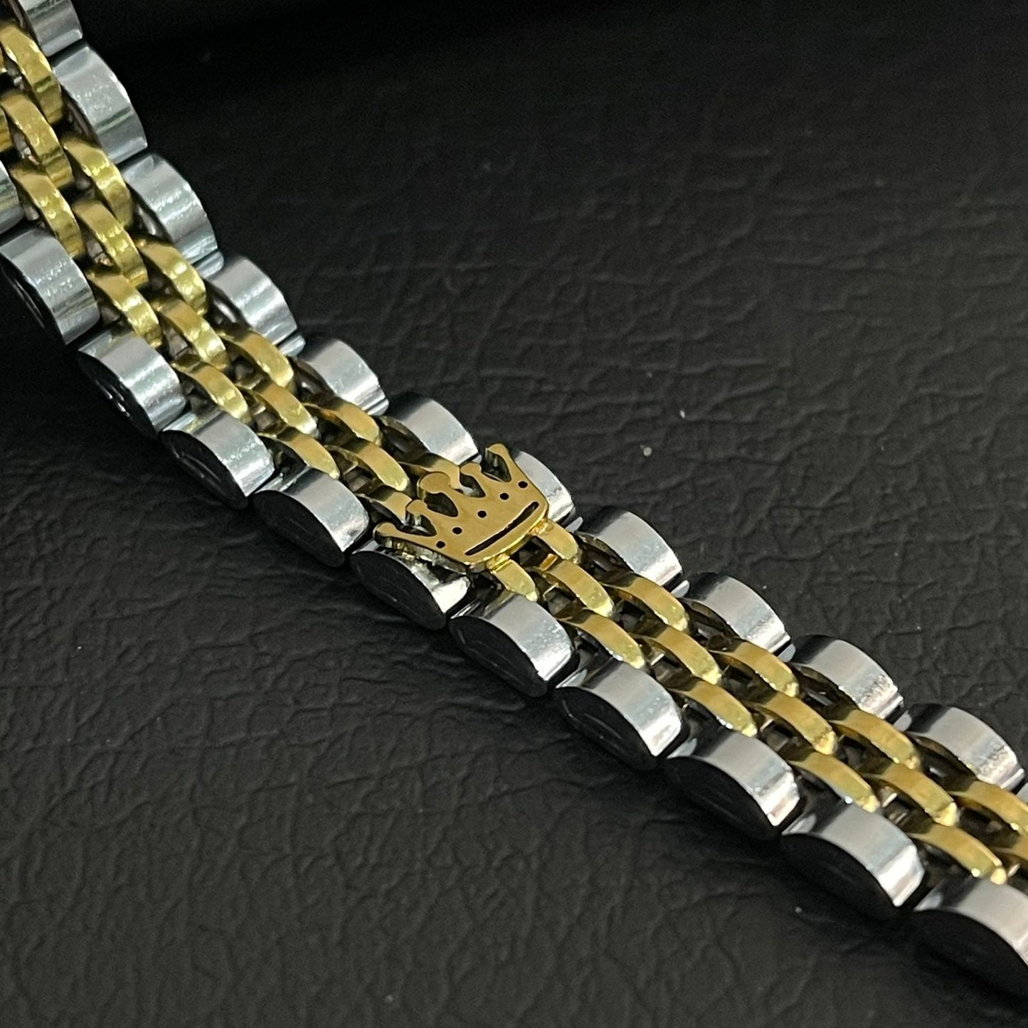 Two-tone silver and gold bracelet on a dark textured surface