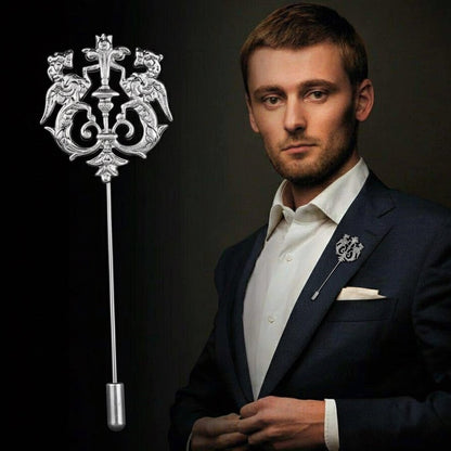 Man in formal attire holding a decorative lapel pin against a dark background