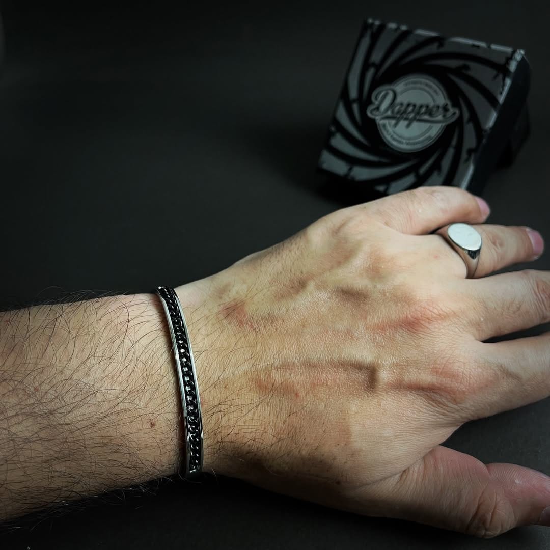 Hand with a ring and bracelet on a dark background