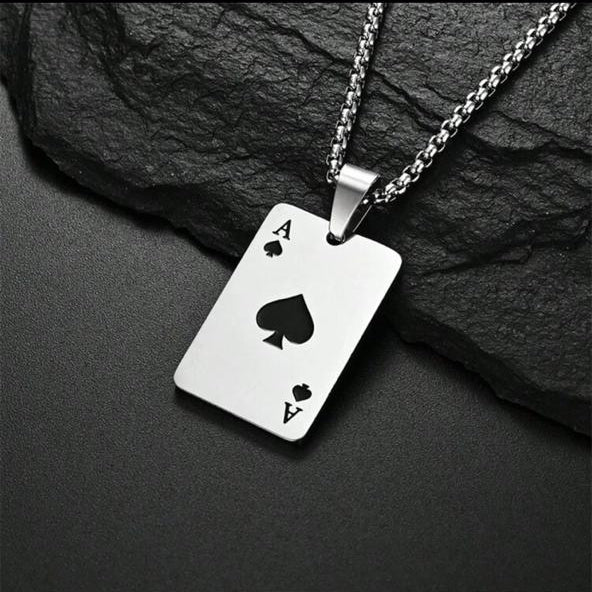 Silver ace of spades necklace on a dark stone background