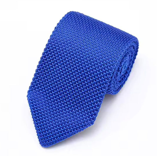 A rolled-up blue textured necktie with a woven honeycomb pattern, displayed on a clean white background.