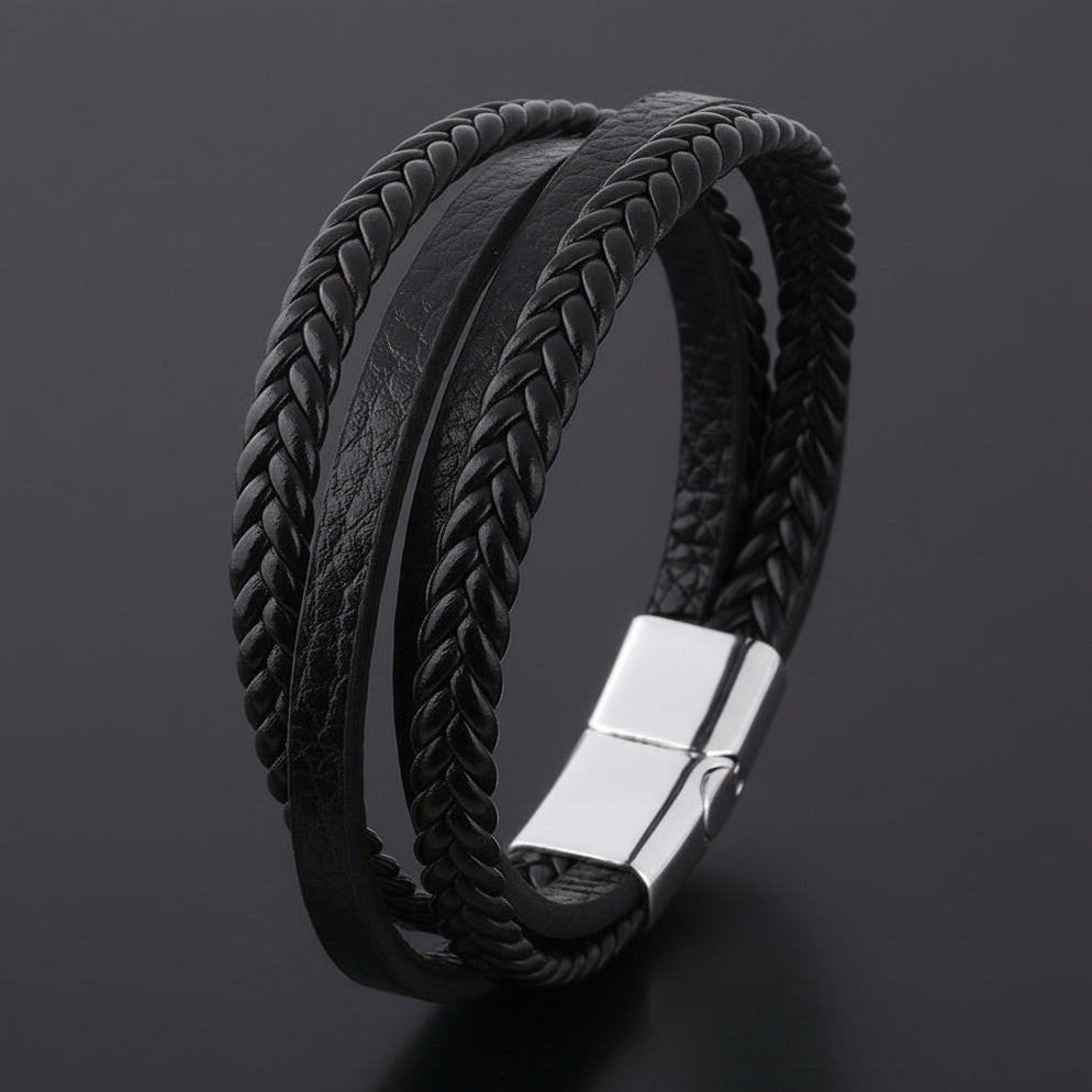 Black braided leather bracelet with a silver clasp on a dark background