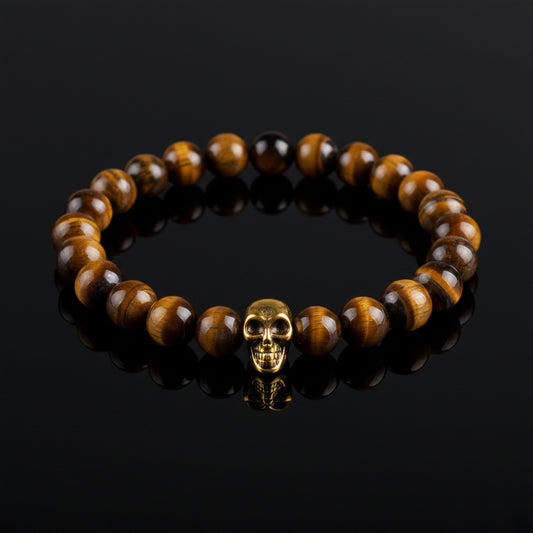 A Tiger Eye bead bracelet with golden skull detailing on a white background